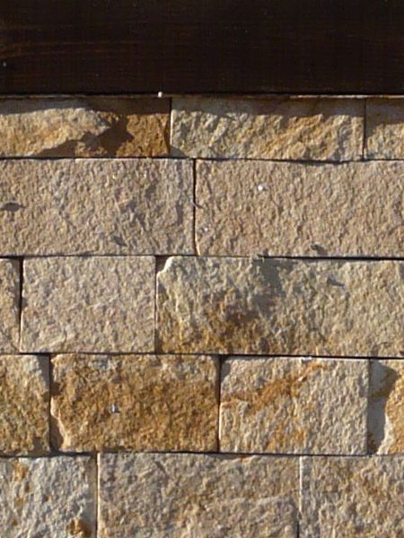 Light stone set linearly with dark wood dividing wall at regular intervals.